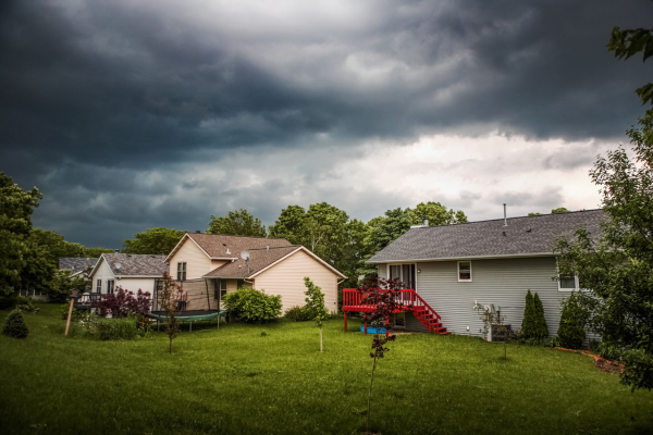 A row of houses in a residential area with a stormy sky in the background.