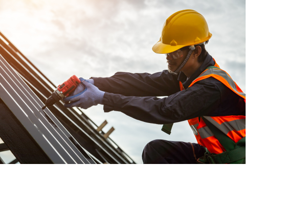 A man wearing a hard hat is working on a solar panel on a roof.