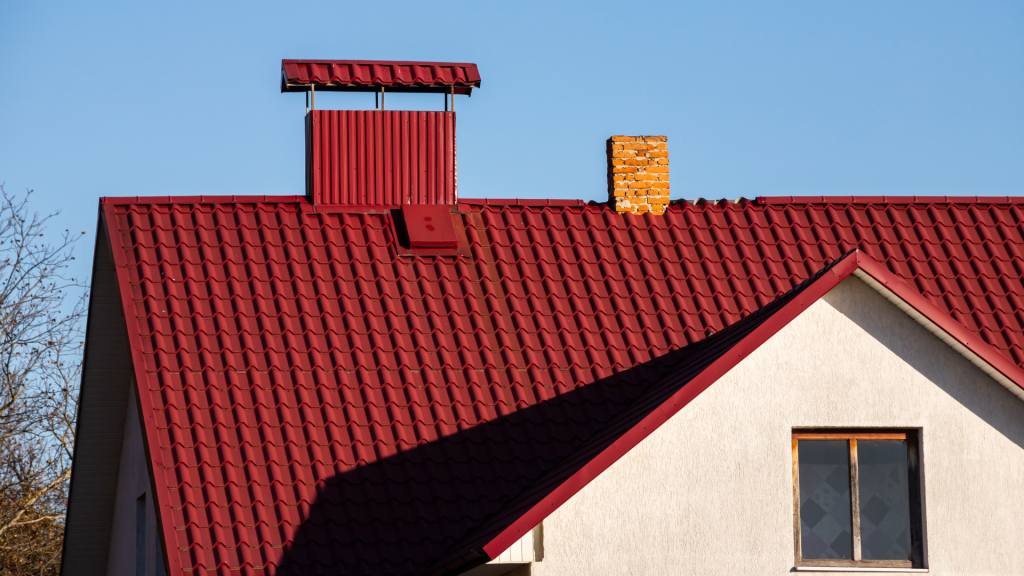 A house with a red roof and a chimney on top of it.