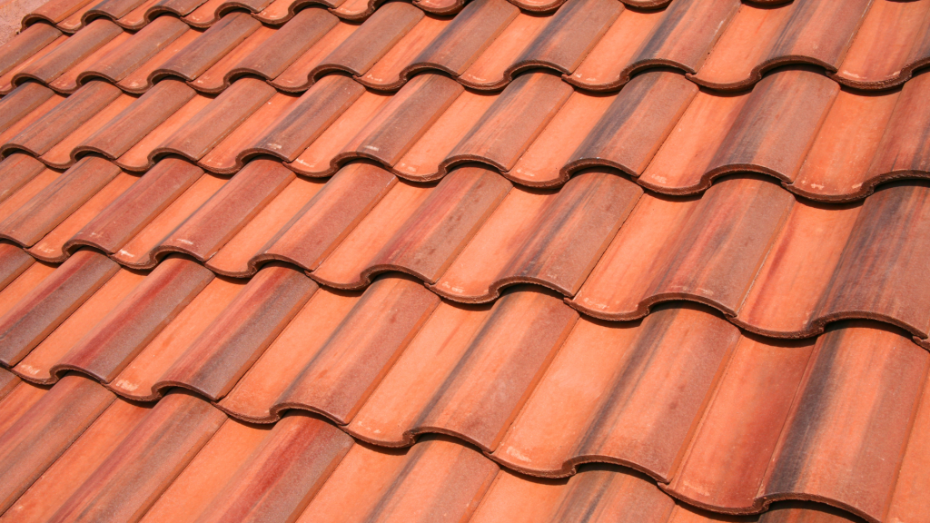 A close up of a row of red tiles on a roof