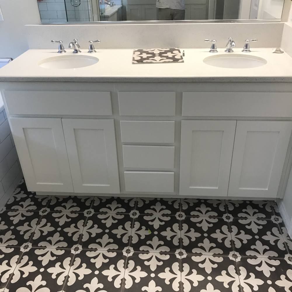 A bathroom with two sinks and a black and white tile floor