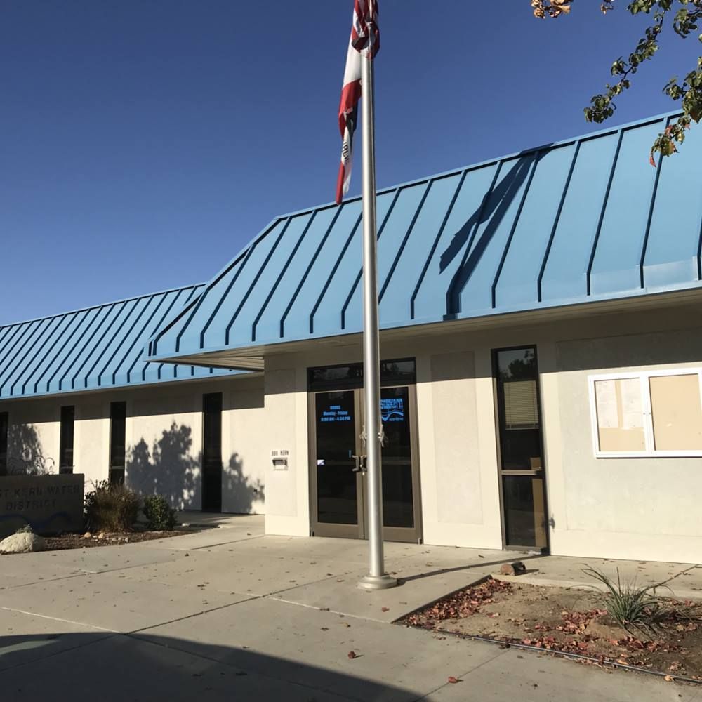 A building with a blue roof and a flag in front of it