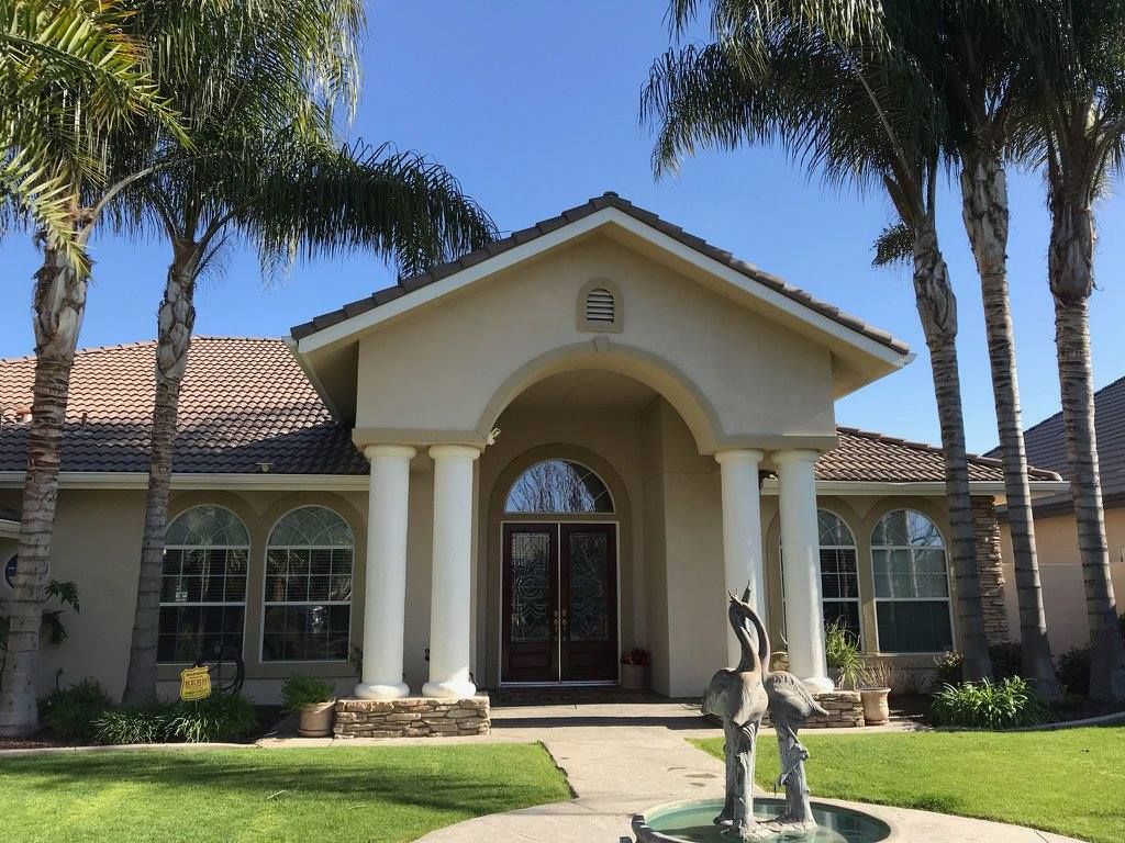 A large house with a fountain in front of it