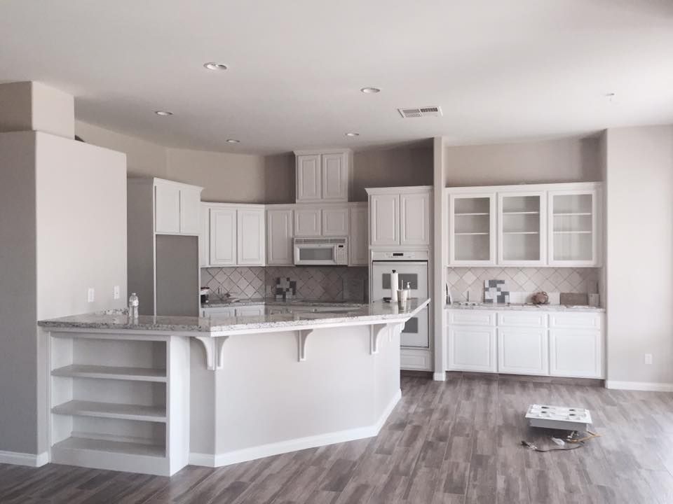 An empty kitchen with white cabinets and a large island