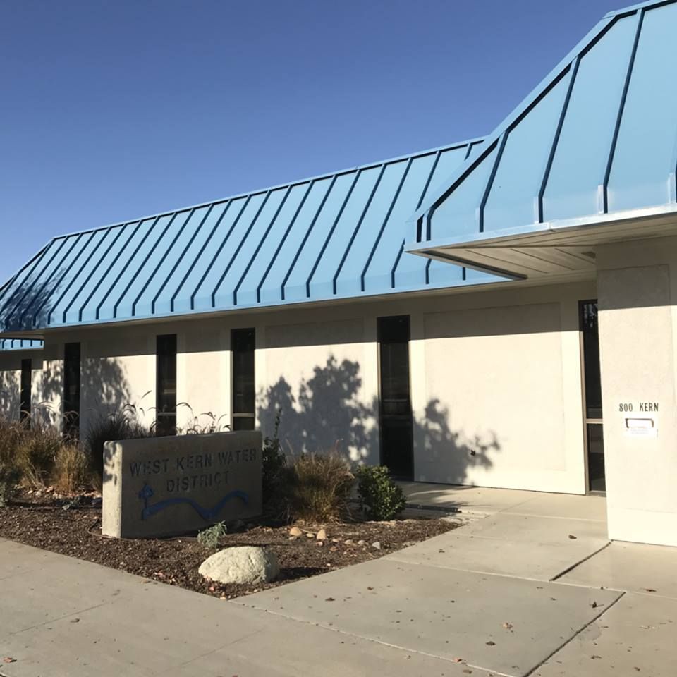 A white building with a blue roof and a sign that says west valley medical center