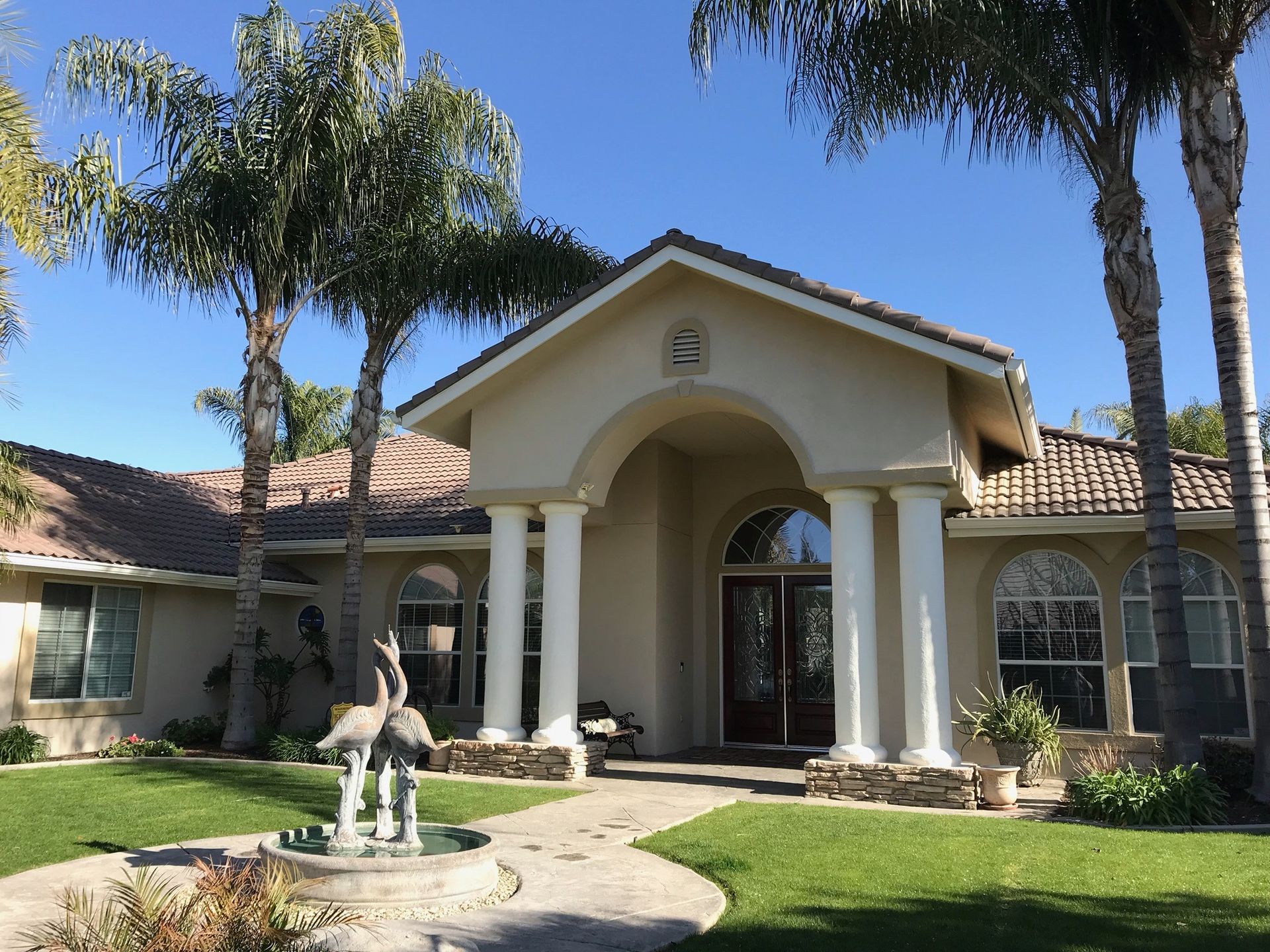 A large house with a fountain in front of it