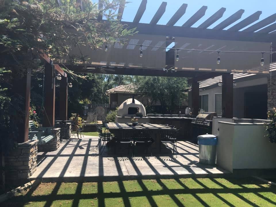 A patio with a table and chairs under a pergola