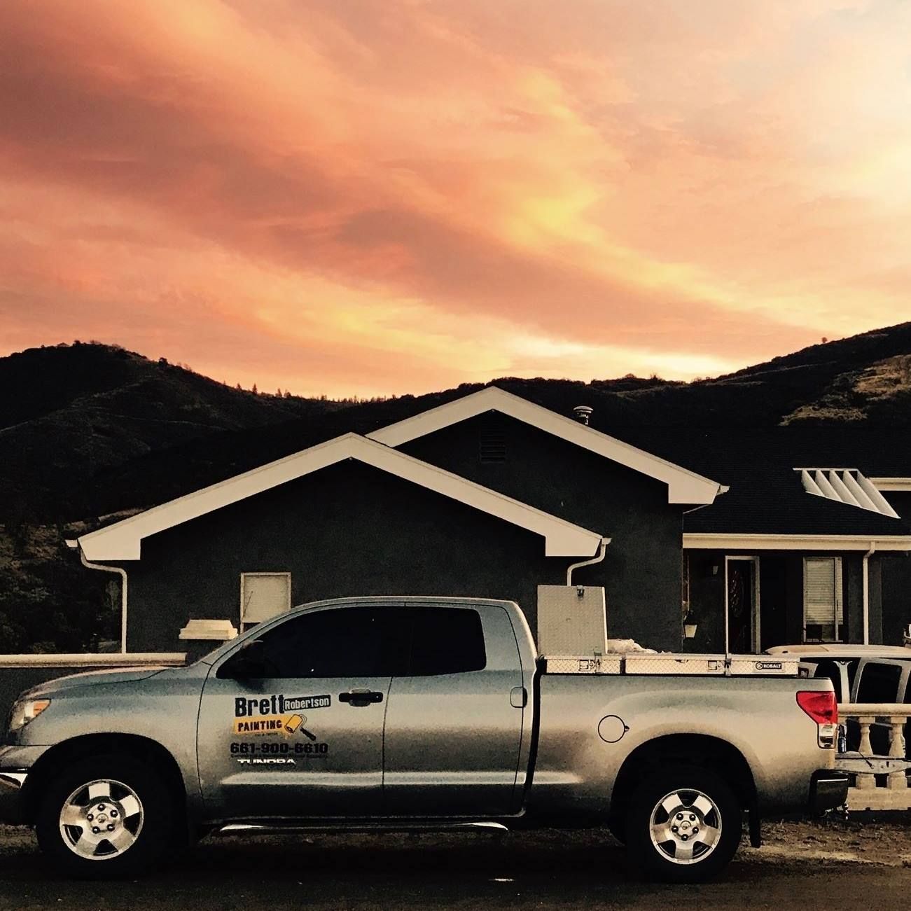 A silver truck is parked in front of a house