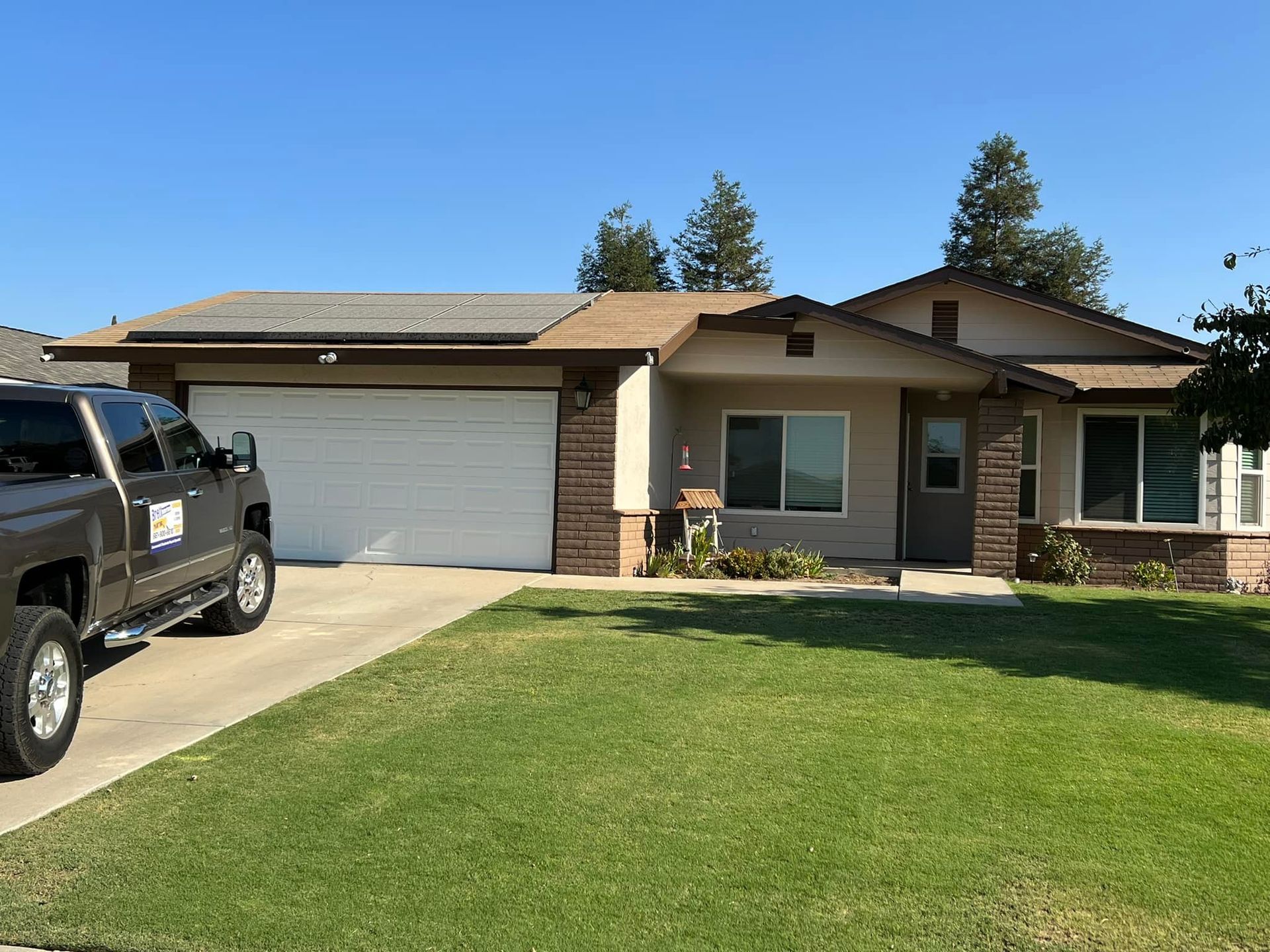 A truck is parked in front of a house with a garage door.