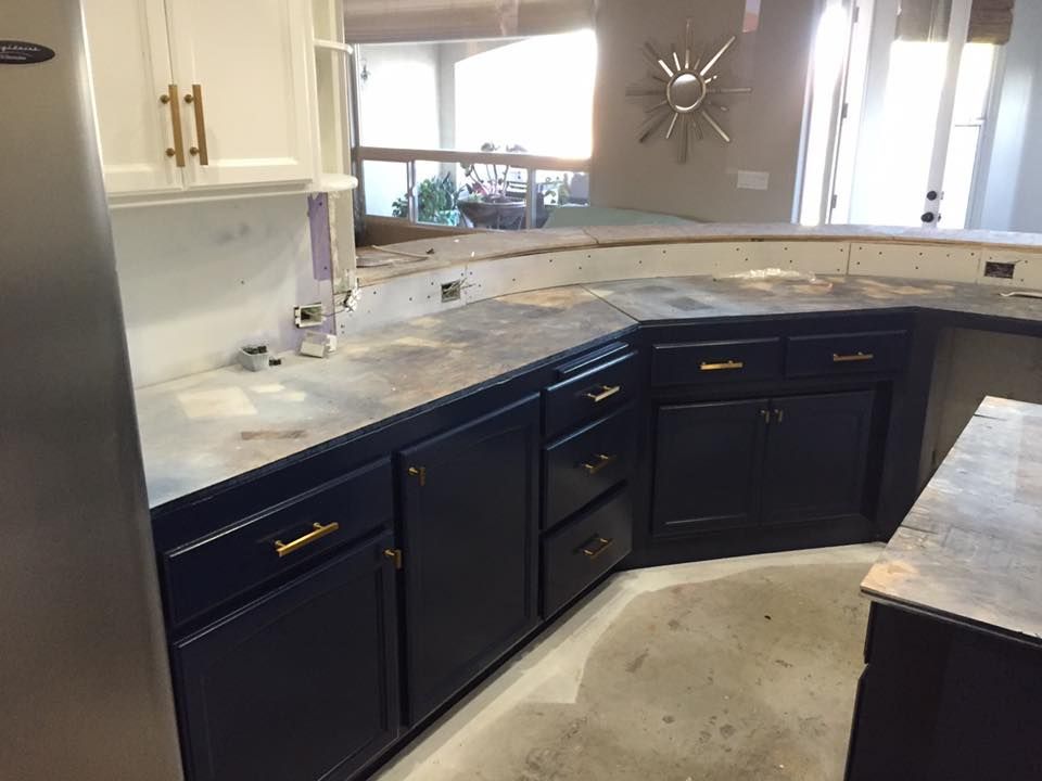 A kitchen with blue cabinets and a stainless steel refrigerator