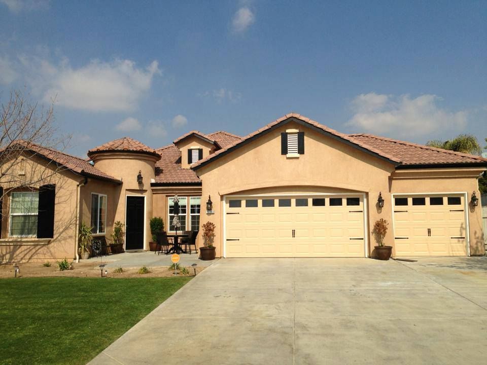 A large house with two garage doors and a driveway