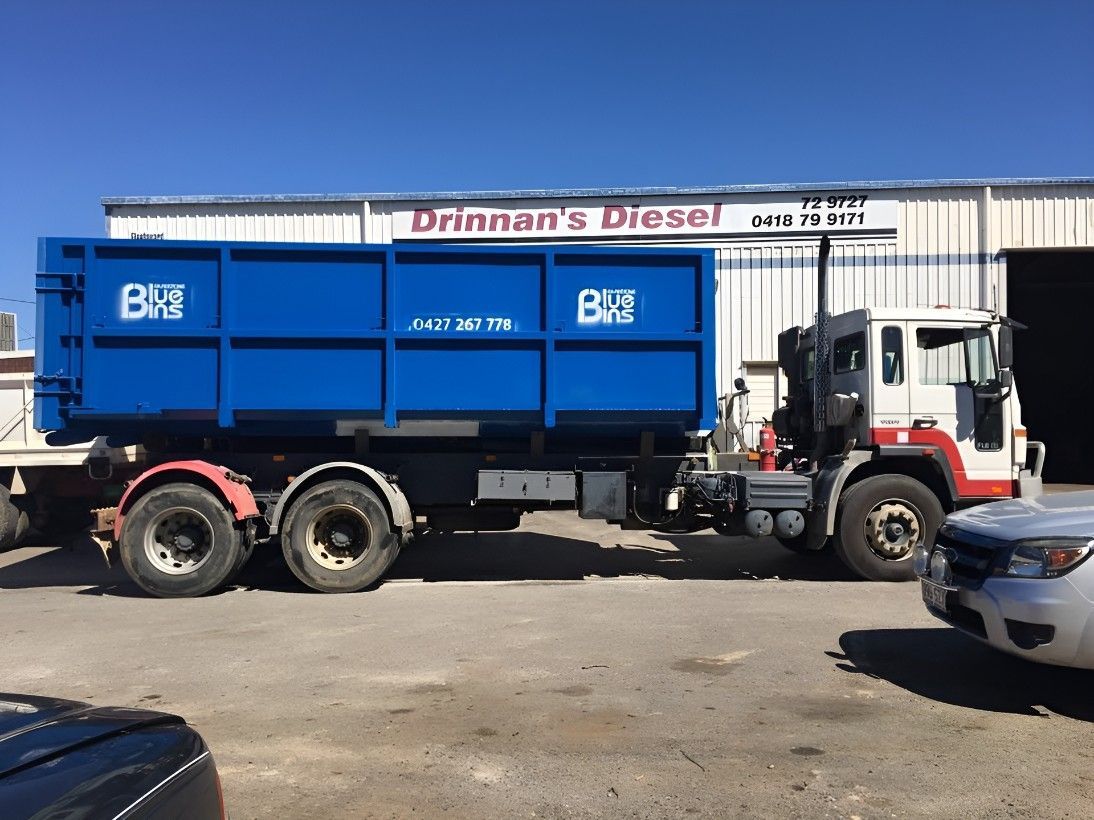 A Blue Dump Truck is Parked in Front of a Building — Drinnan's Diesel & Automotive Repairs In Gladstone Central, QLD