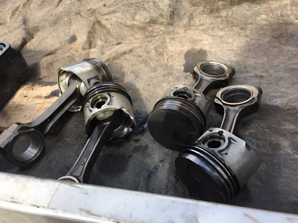 A Bunch of Pistons and Connecting Rods Are Sitting on a Table — Drinnan's Diesel & Automotive Repairs In Gladstone Central, QLD