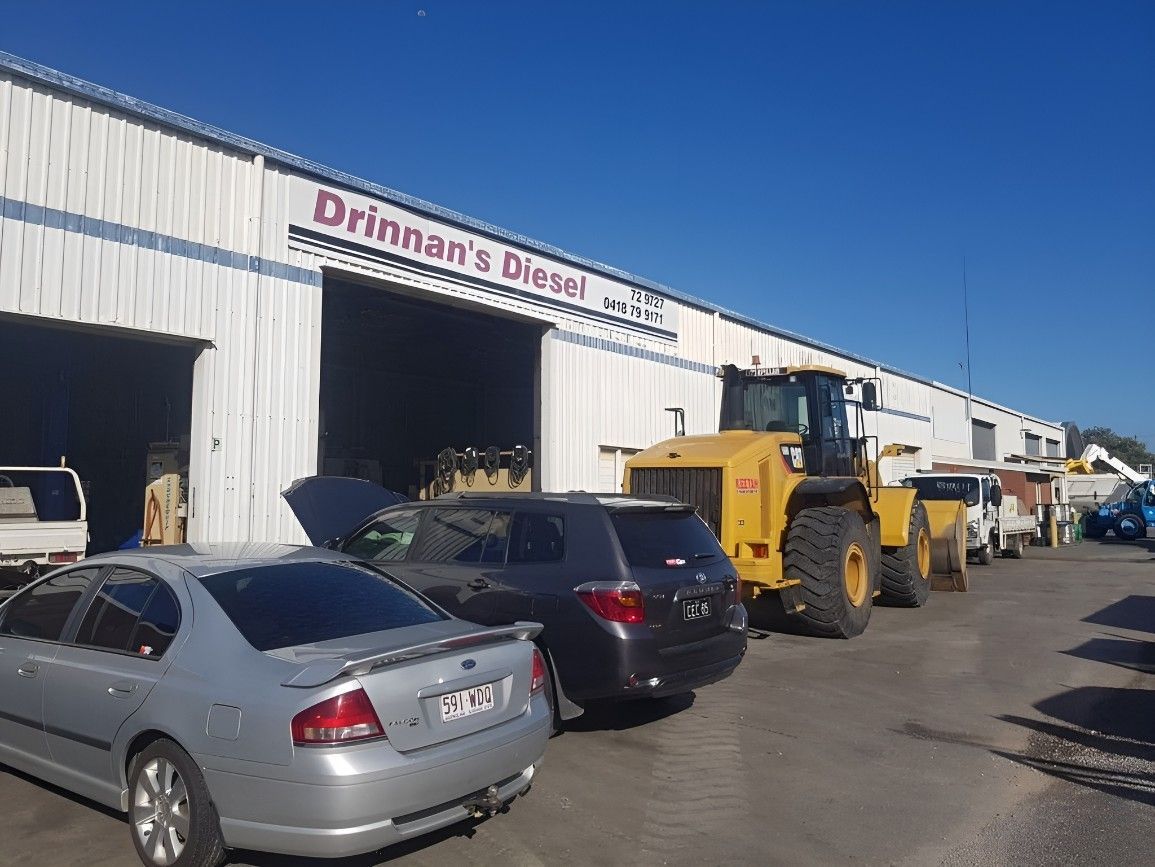 A rOw of Cars Are Parked in Front of a Building — Drinnan's Diesel & Automotive Repairs In Gladstone Central, QLD