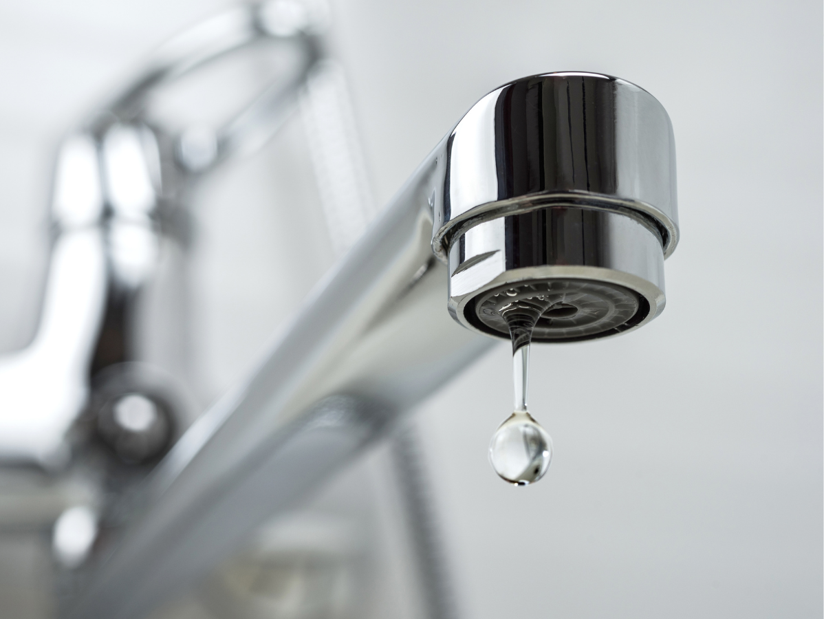Chrome faucet with a water droplet falling.