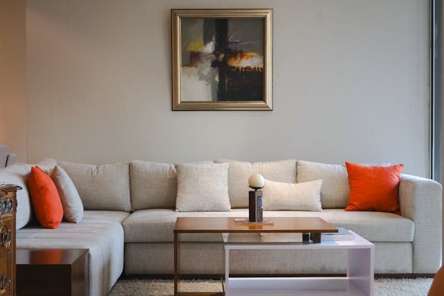 a living room with beige and orange decor elements