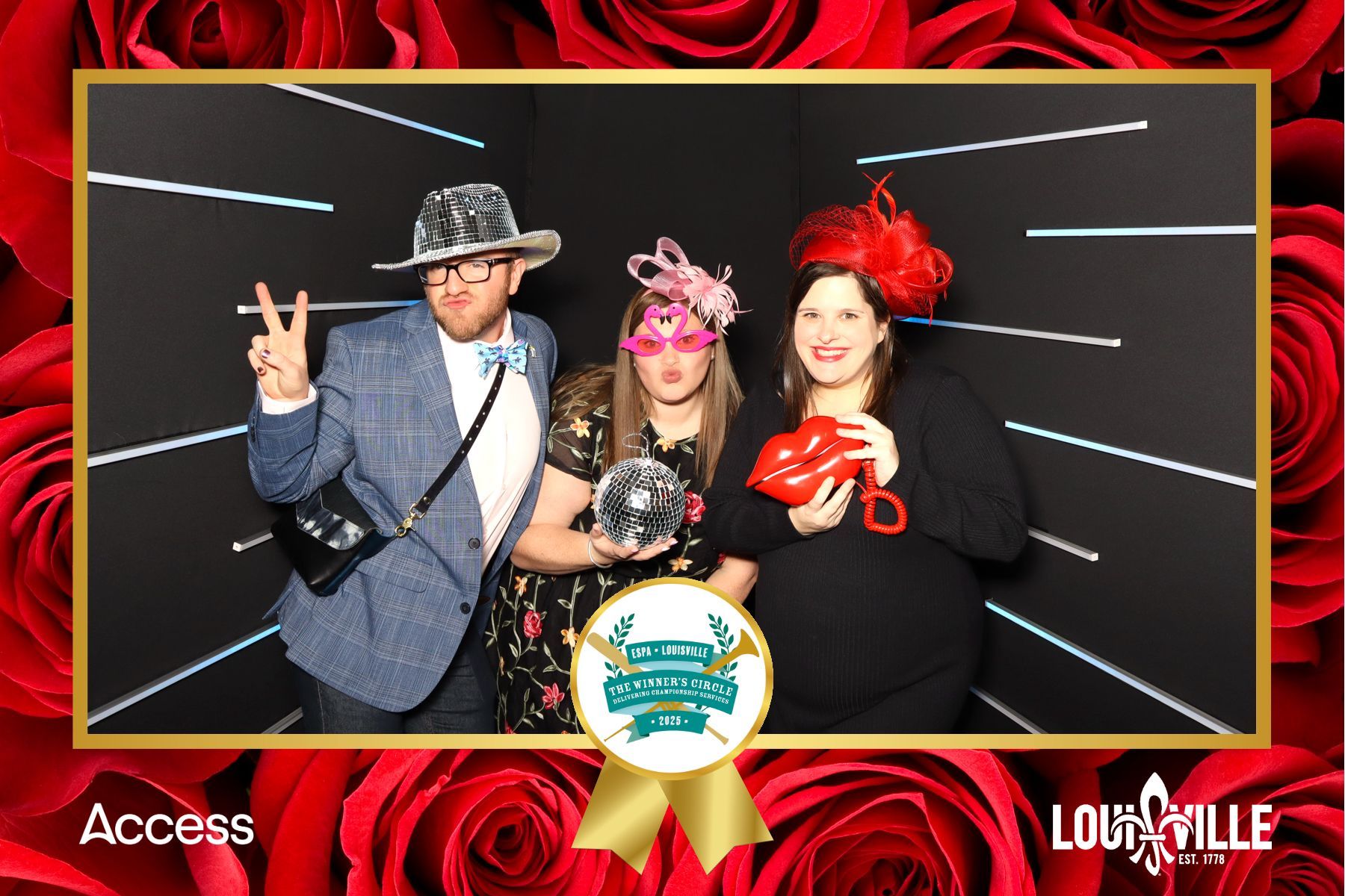 A group of people are posing for a picture in a photo booth with red roses in the background.