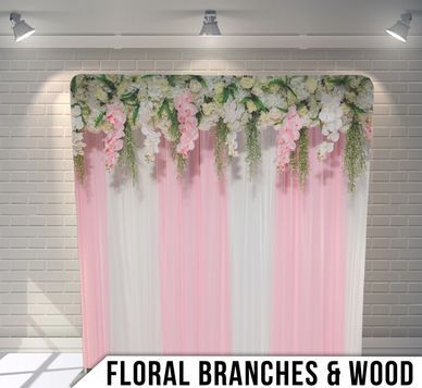 A pink and white backdrop with floral branches and wood