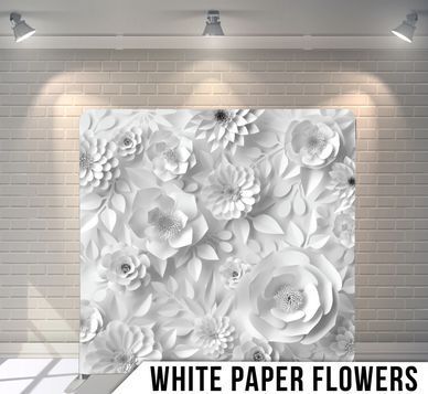 A room with a brick wall and white paper flowers on it.