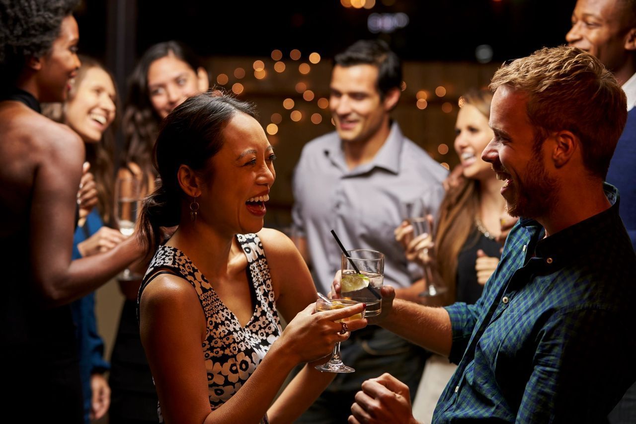 A group of people are having a party and toasting with champagne glasses.