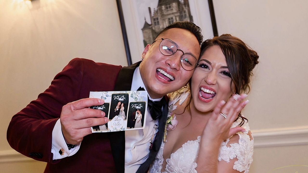 A bride and groom are posing for a picture at their wedding reception.