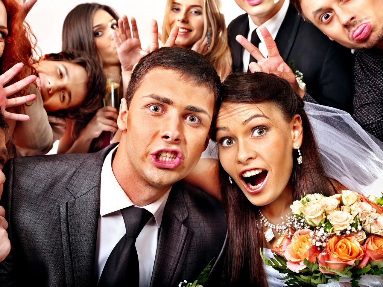 A bride and groom are posing for a picture with their wedding party