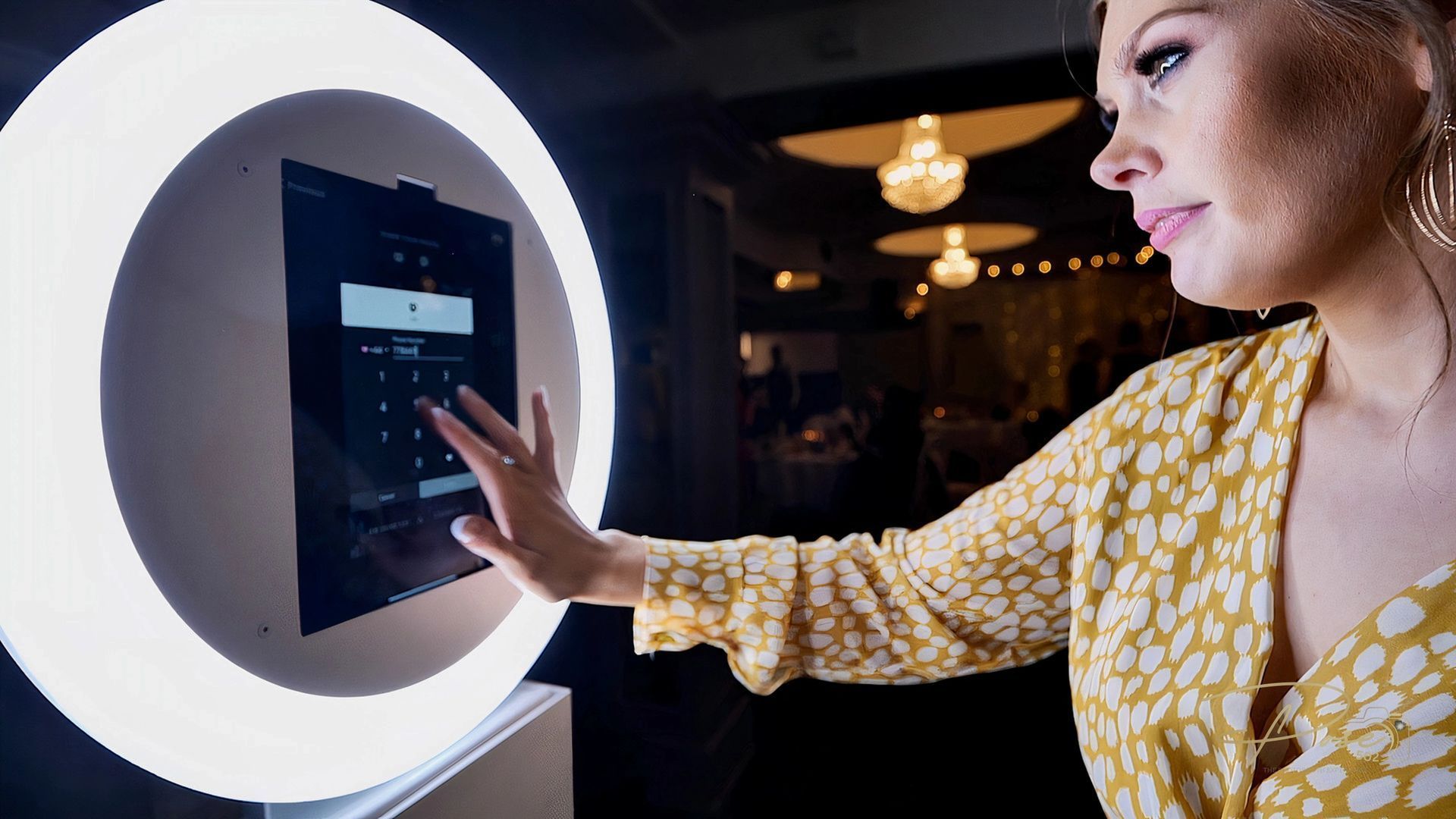 A woman is using a ring light to take a picture of herself.