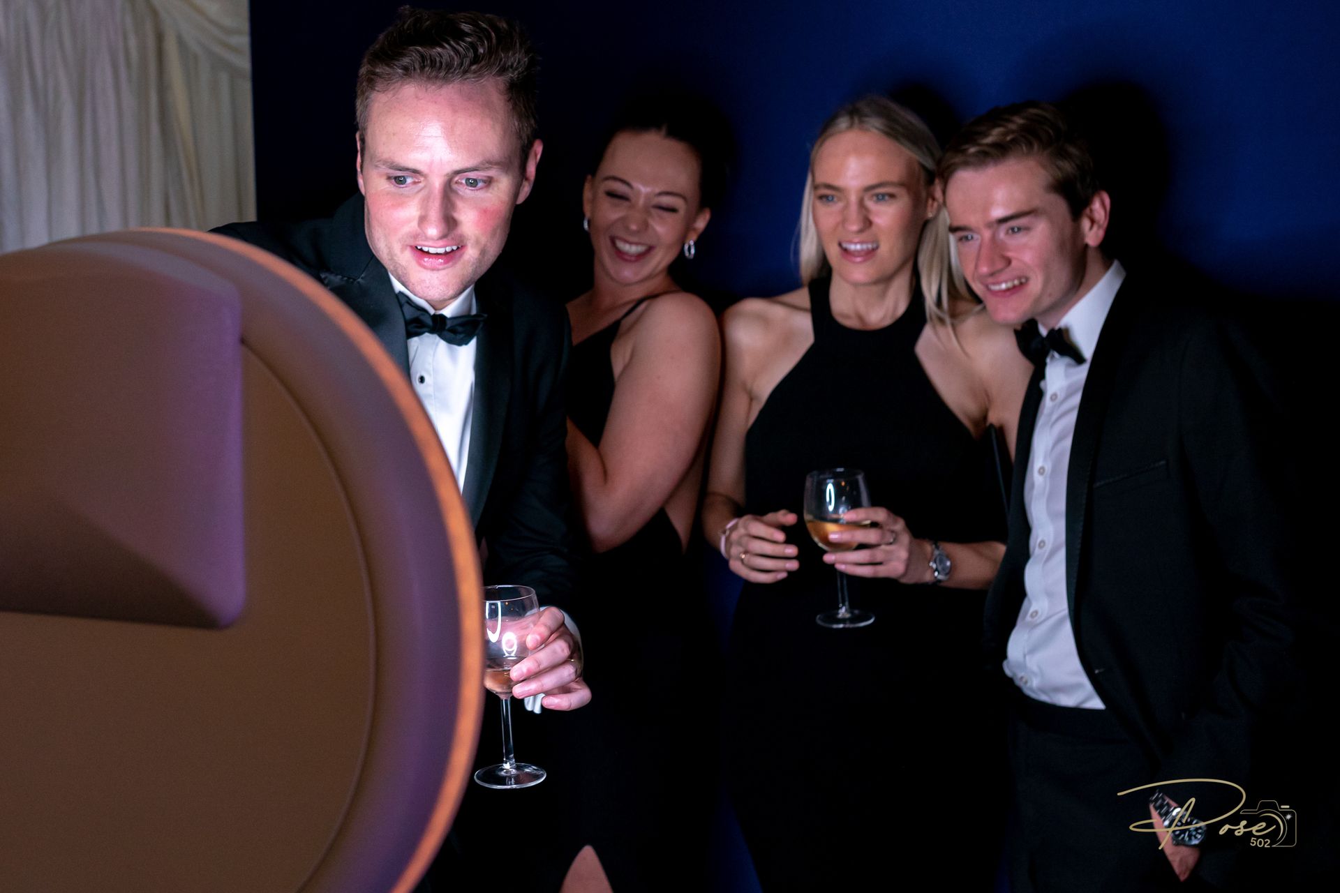 A group of people are posing for a picture in a photo booth.