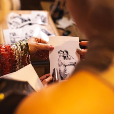 A woman is holding a picture of a man and woman hugging each other.