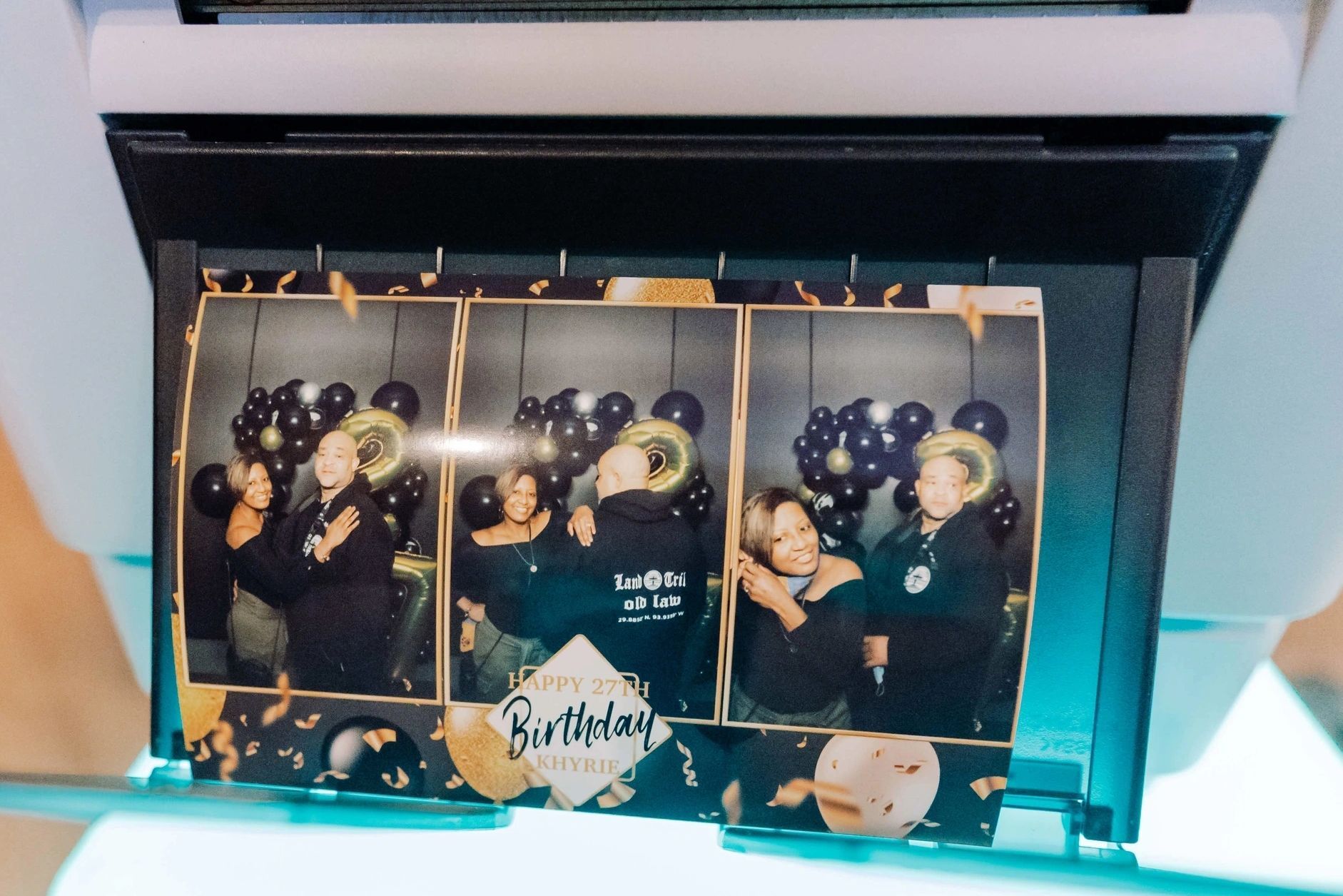 A photo booth with balloons and the word birthday on it