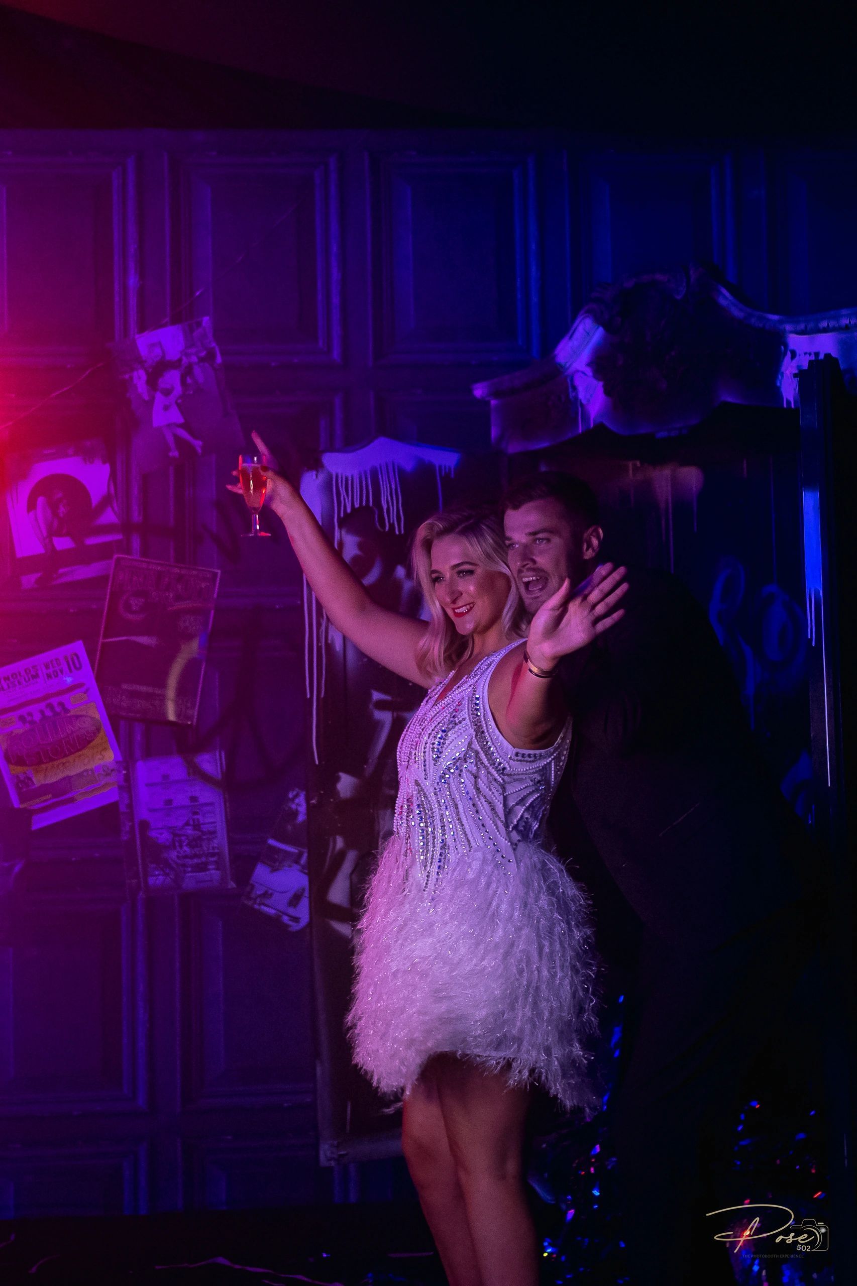 A man and a woman are dancing on a stage in a dark room.