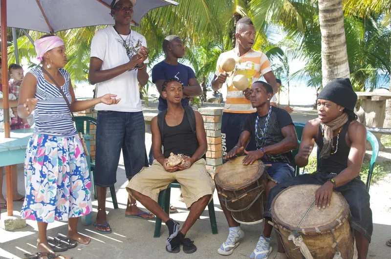 A group of people are playing drums and singing in a park