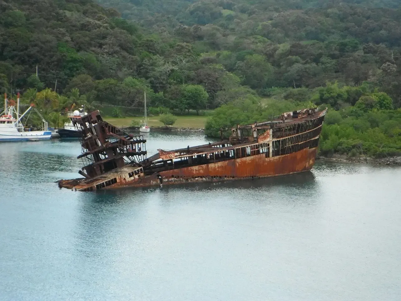 An old rusty ship is floating on top of a body of water.