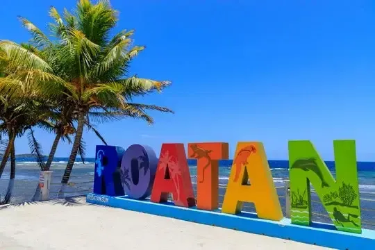 A sign on a beach that says hoatan