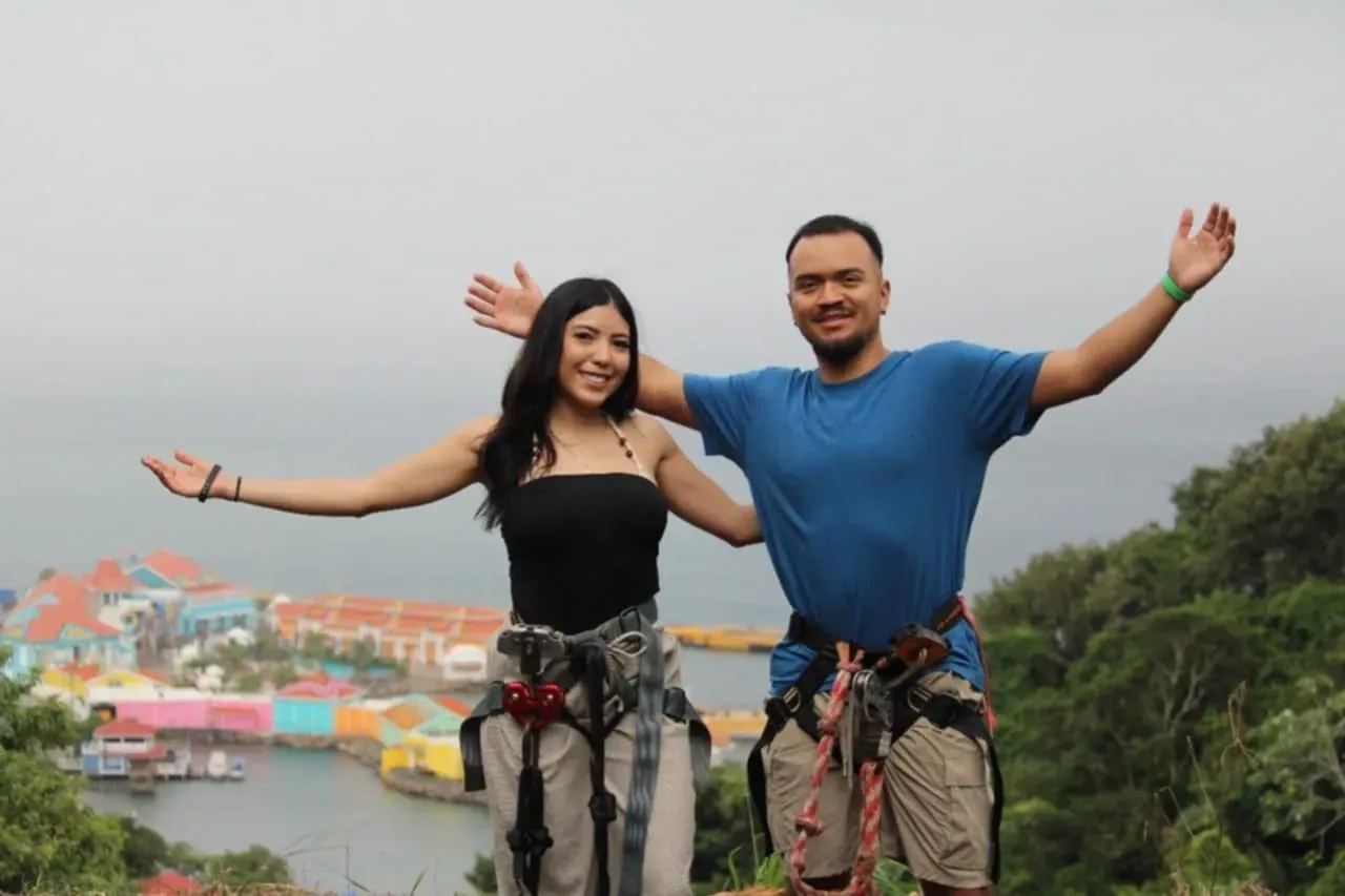 A man and a woman are standing next to each other with their arms outstretched.