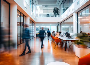 A group of people are walking down a hallway in an office building.