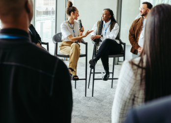 A group of people are sitting in a circle talking to each other.