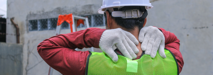 back of construction worker's head and shoulders with hands massaging his neck