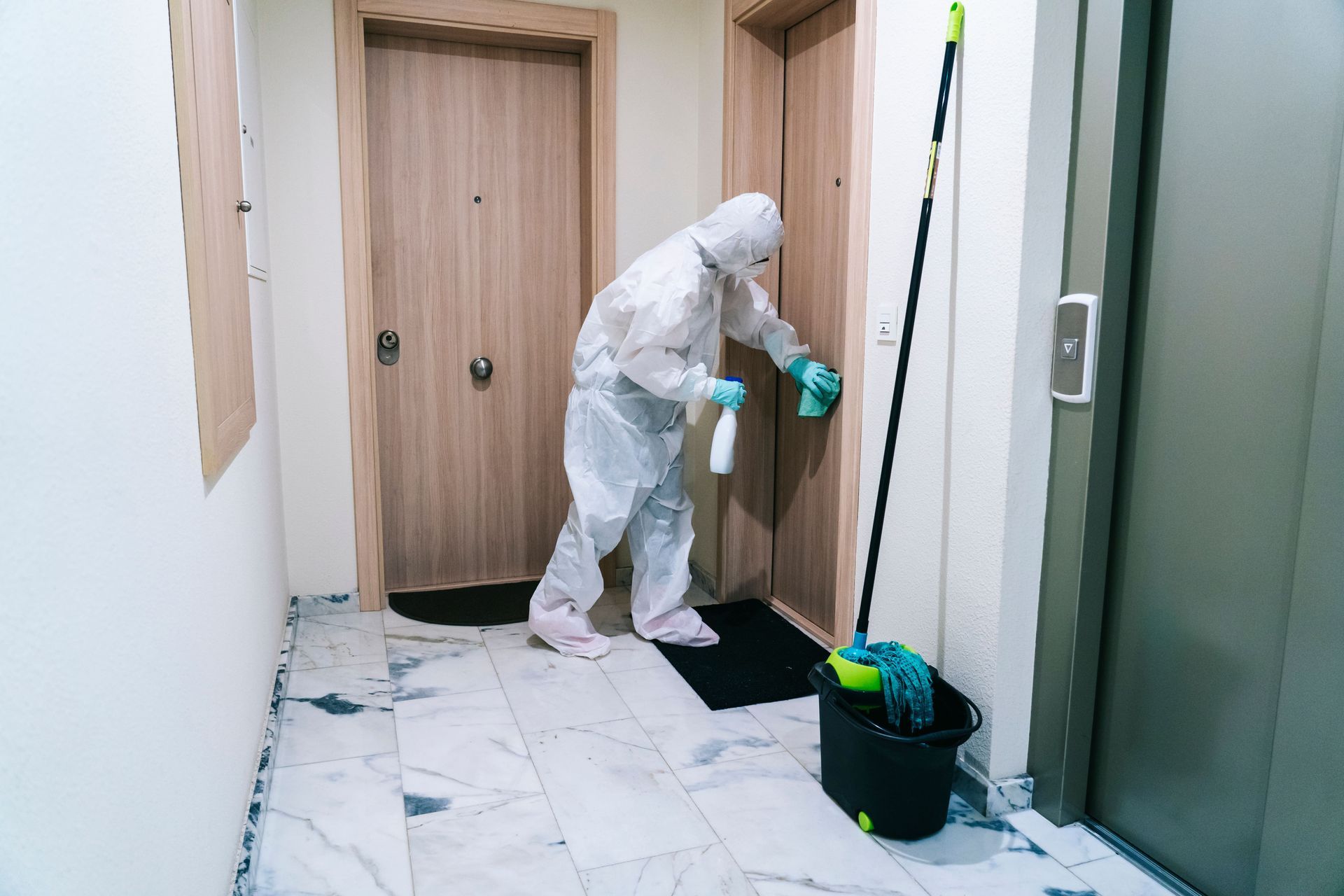 a person in a protective suit is cleaning a door