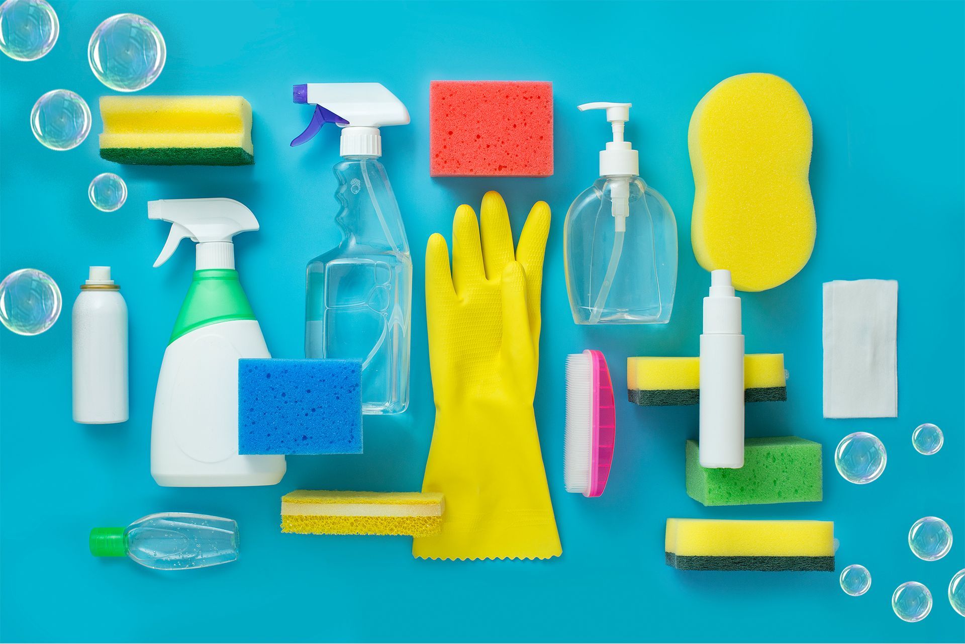 a variety of cleaning supplies are laid out on a blue surface Cleaning for Small Businesses