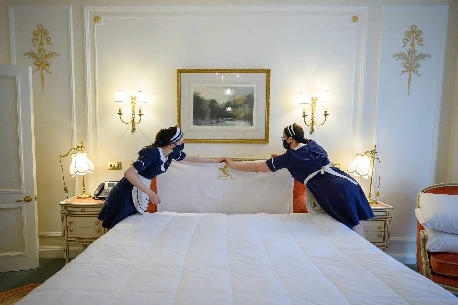 two staff doing standard Cleaning Services in a bedroom  