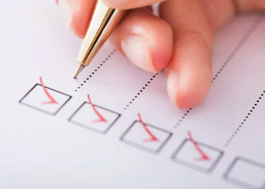a person is checking off a checklist with a pen