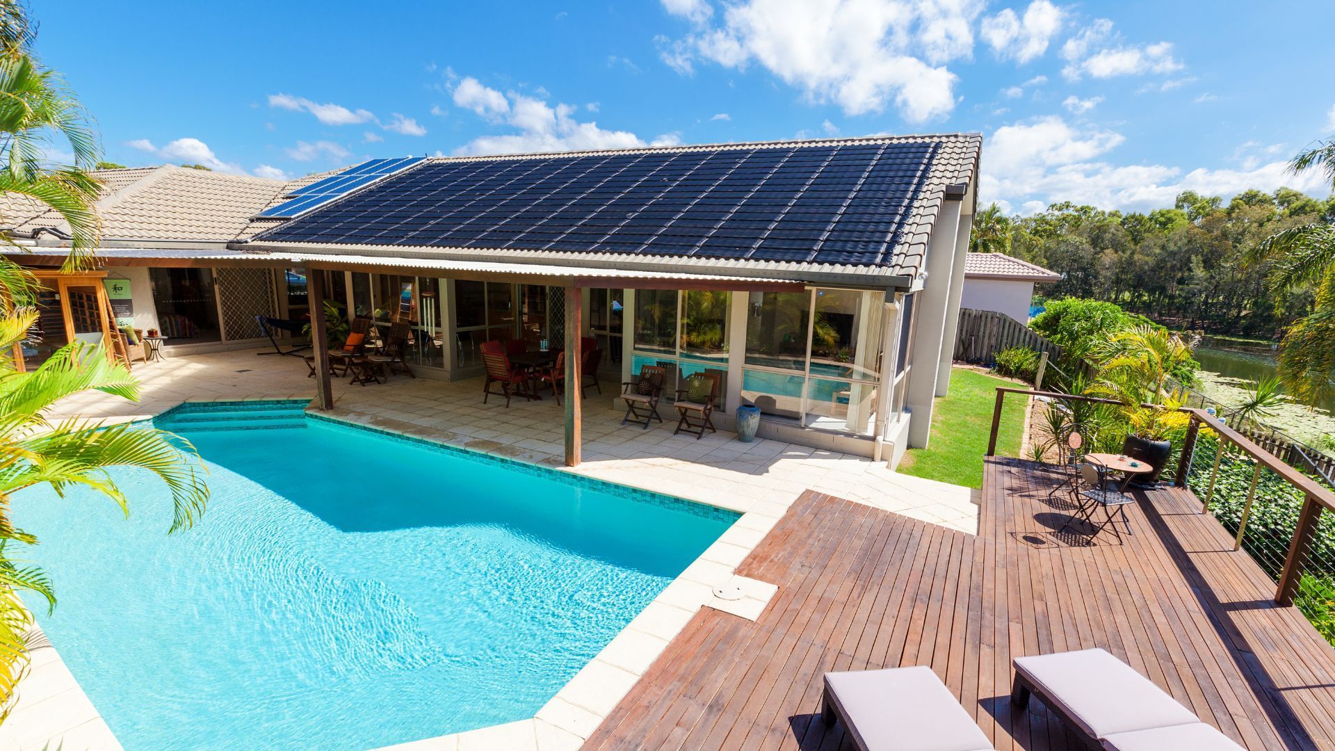 A house with a swimming pool and solar panels on the roof.
