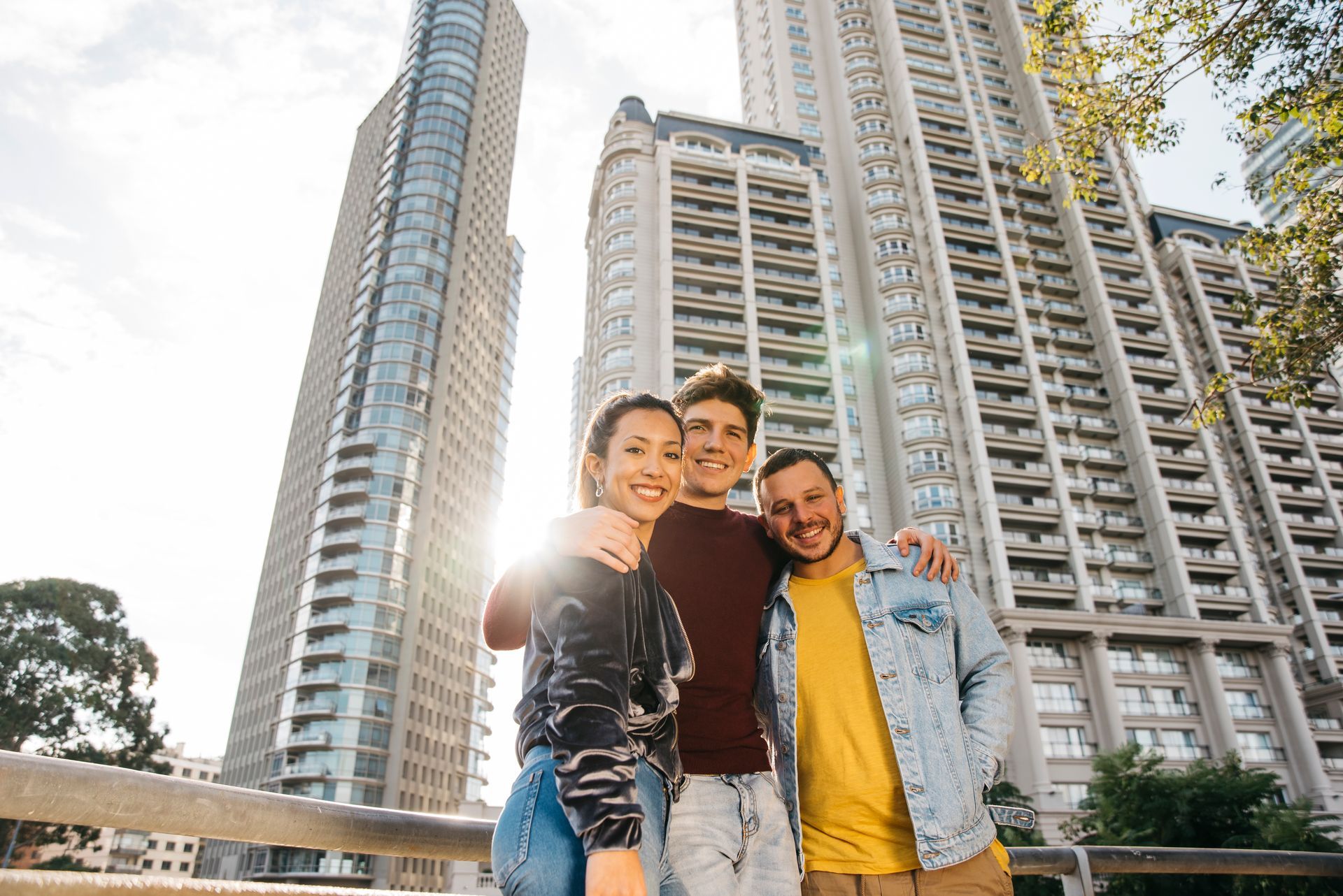 A group of young people are posing for a picture in front of a tall building.