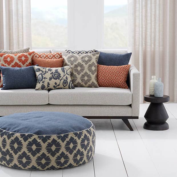 Grey couch with custom colourful cushions