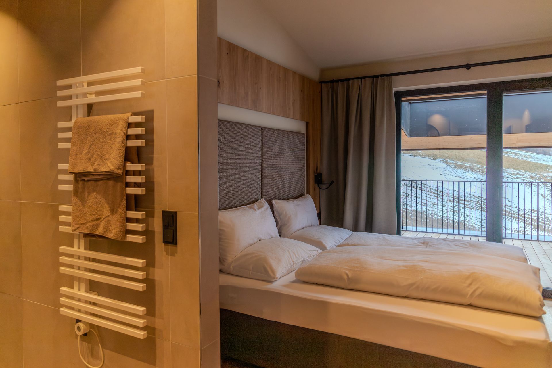 Ein modernes Hotelzimmer mit einer Schlafzimmer, mit einer Wand aus Holz hinter einem weißen Bett