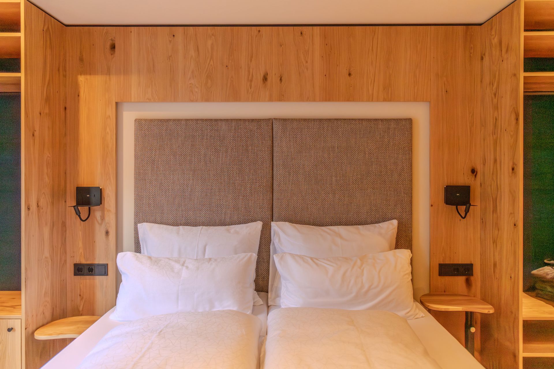 Ein modernes Hotelzimmer mit einer Schlafzimmer, mit einer Wand aus Holz hinter einem weißen Bett