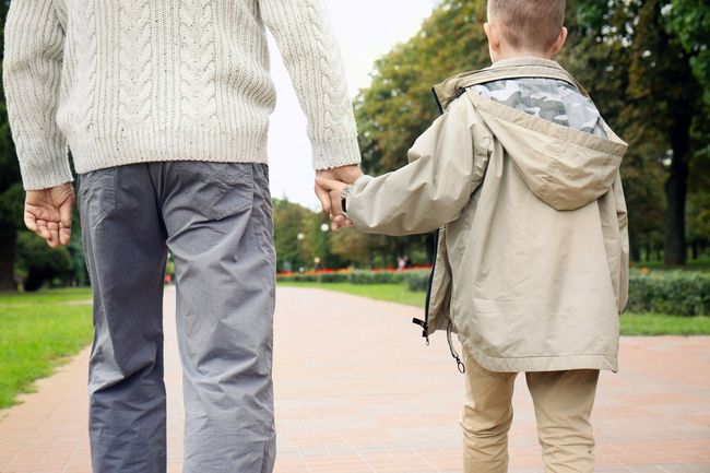 The front door of a house with a porch and plants in front of it.