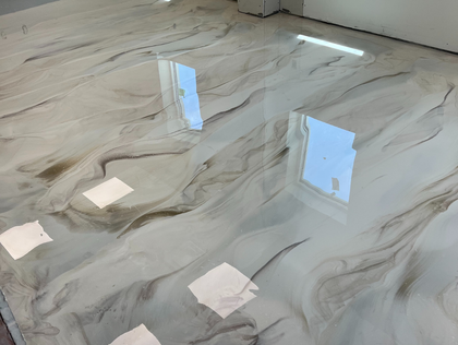 Swirled epoxy floor, white and brown, reflecting light.