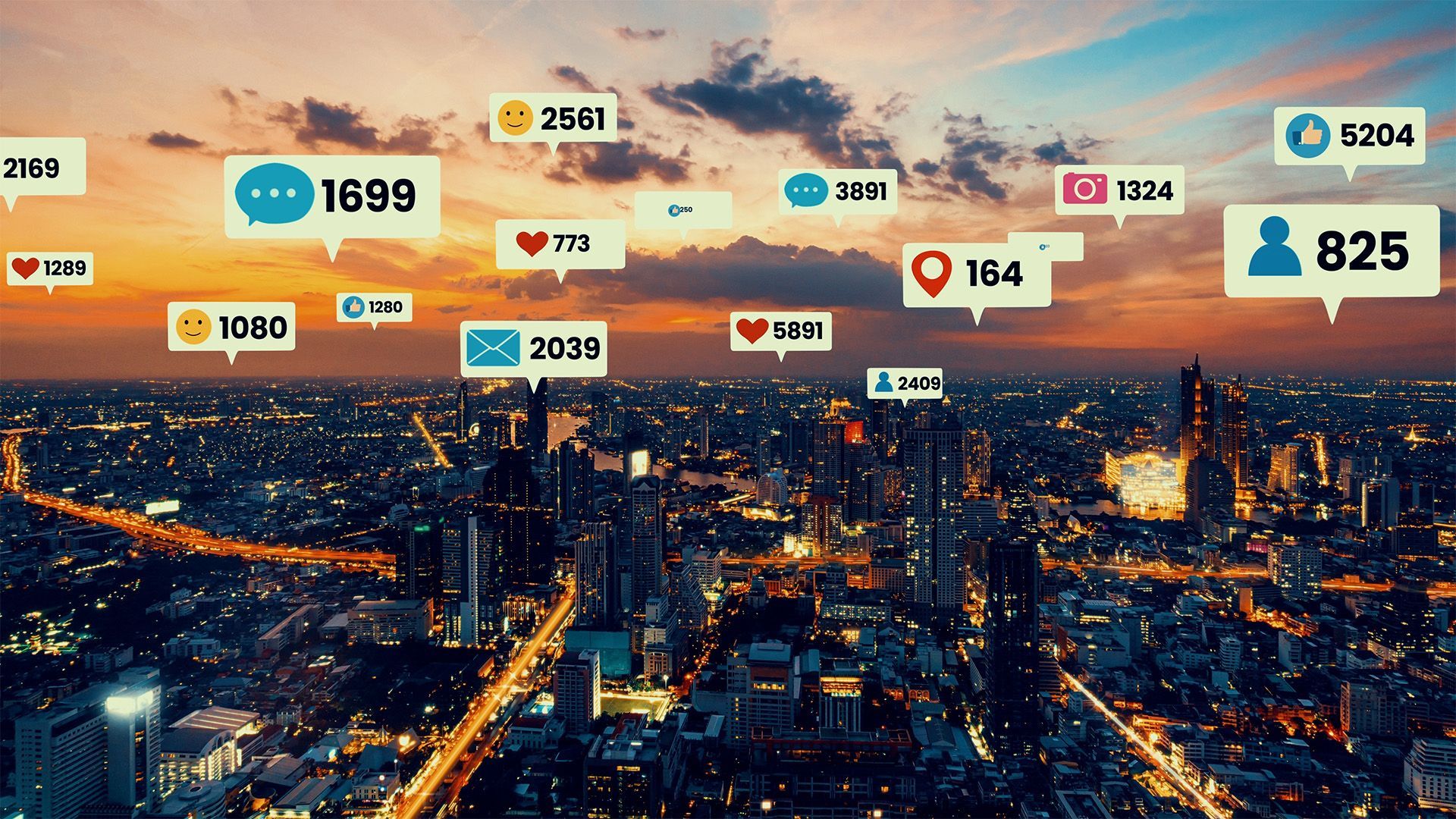 an aerial view of a city at night with social media icons floating in the air .